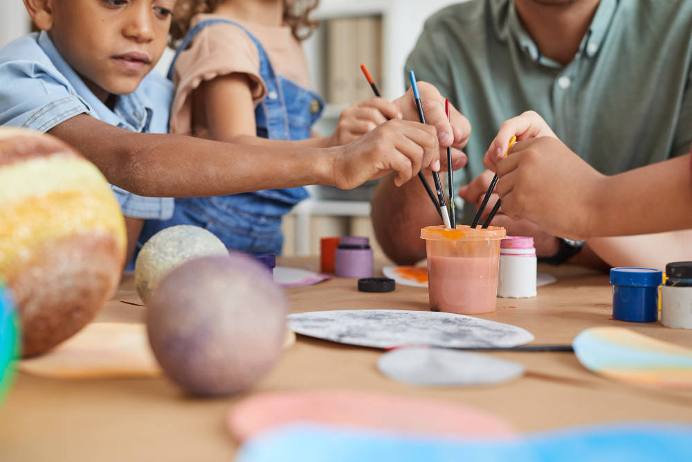 multi-ethnic-group-kids-holding-brushes-painting-planet-model-while-enjoying-art-craft-lesson-school-development-center (1)